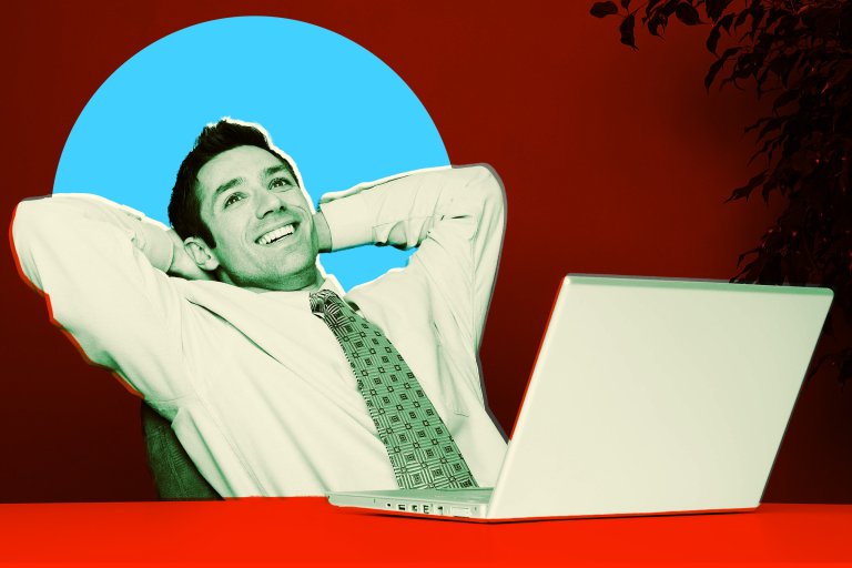Man in a dress shirt and patterned tie leaning back with hands behind his head, smiling, sitting at a red desk with a silver laptop in front of him. The background is dark red with a large blue circle behind his head and some plant leaves visible on the right side.