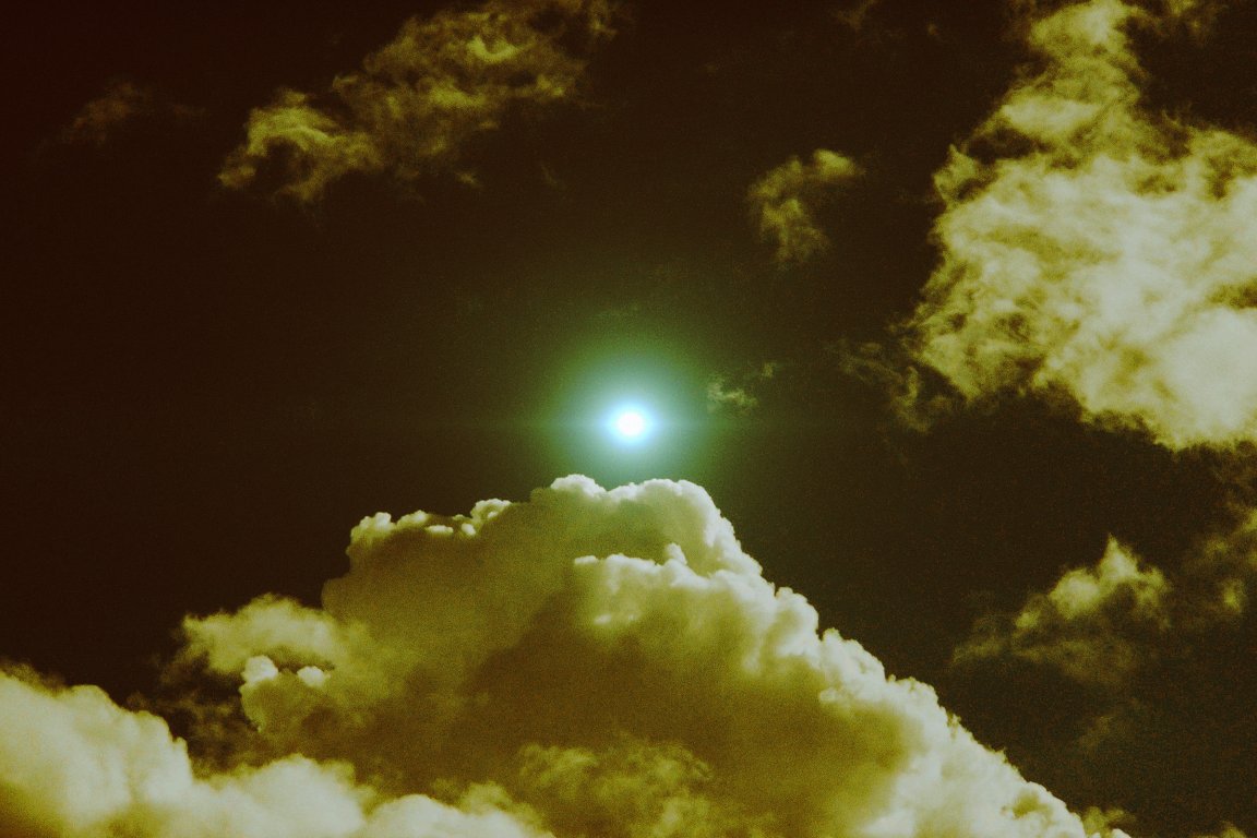 A photo illustration showing a glint of light above in the sky, suggesting the presence of a far-off drone above.