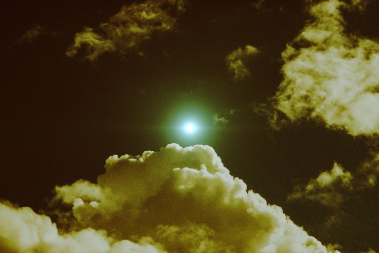 A photo illustration showing a glint of light above in the sky, suggesting the presence of a far-off drone above.