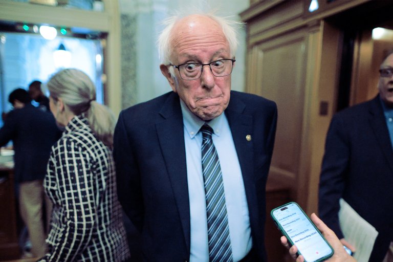 A photograph of senator Bernie Sanders talking to reporters at the US Capitol.
