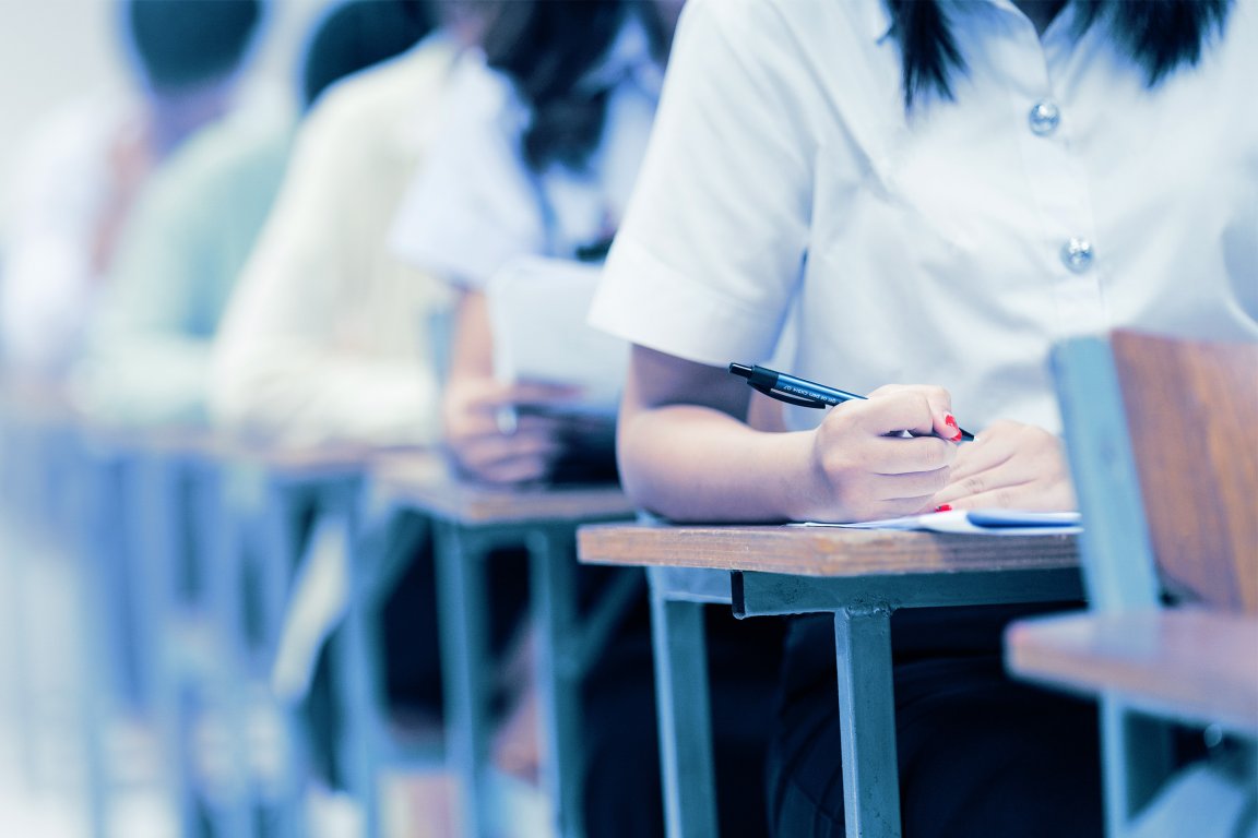 A color-treated photograph of students taking an exam.