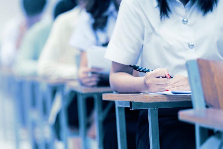 A color-treated photograph of students taking an exam.