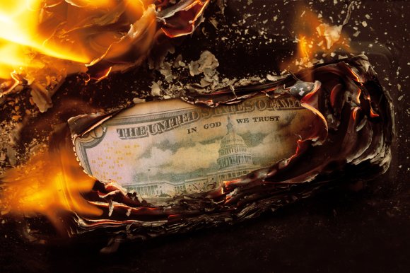 Photograph of a stack of money burning.