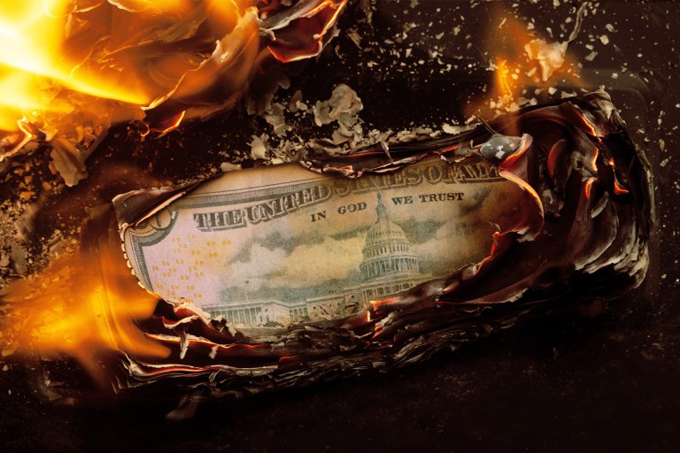 Photograph of a stack of money burning.