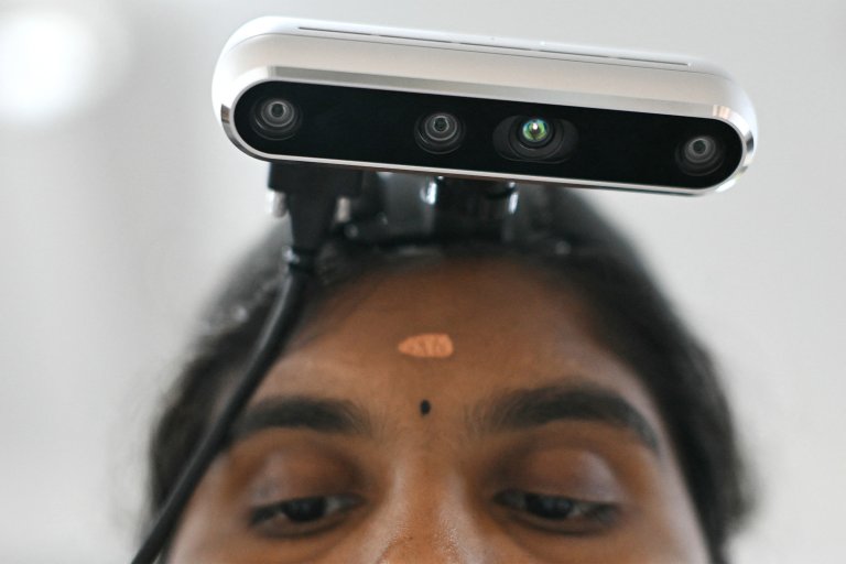 A photograph featuring a close-up of a worker wearing a camera on her head recording actions through motion capture.