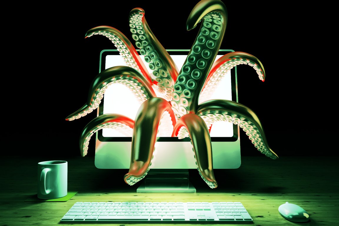 A computer monitor on a wooden desk with large, green tentacles emerging from the screen. The scene is illuminated with a greenish light, and a white keyboard and mouse are placed in front of the monitor.