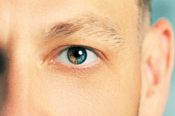 A color-treated close-up photograph of a man's eye where the iris color changing from brown to blue.