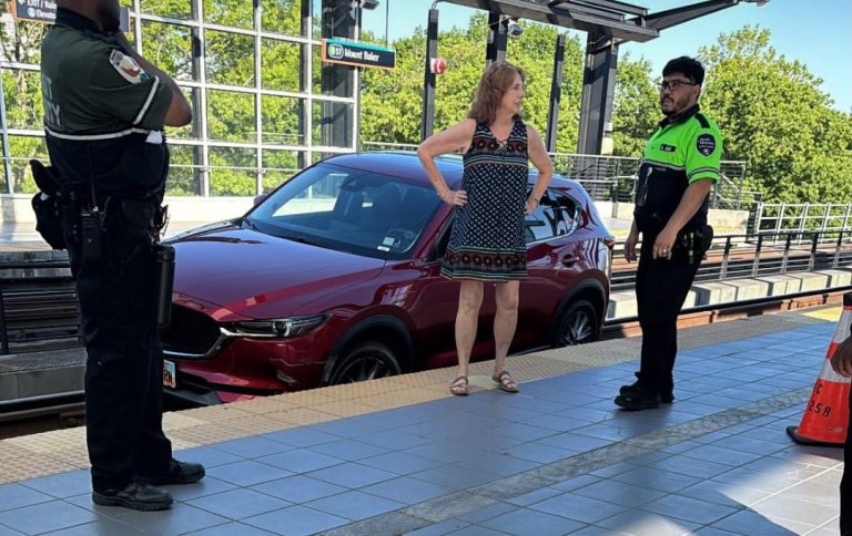 Screenshot of a woman and officers standing outside her car which is parked on the Seattle lightrail.