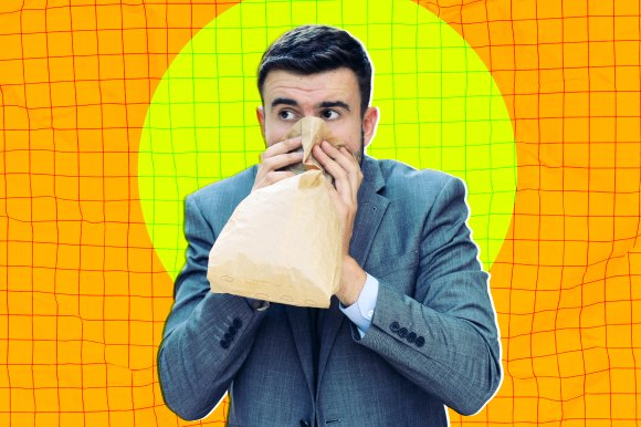 A photo illustration of a businessman anxiously breathing into a paper bag in an attempt to calm himself down.