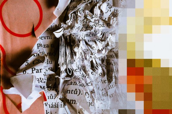 Crumpled and torn pages of a printed text with black letters on white paper, partially overlapping a fabric with a pinkish hue and large red circles. The right side of the image is pixelated with blocks of yellow, orange, and brown colors.