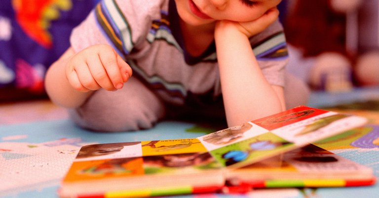 A photo of a young child reading a picturebook.