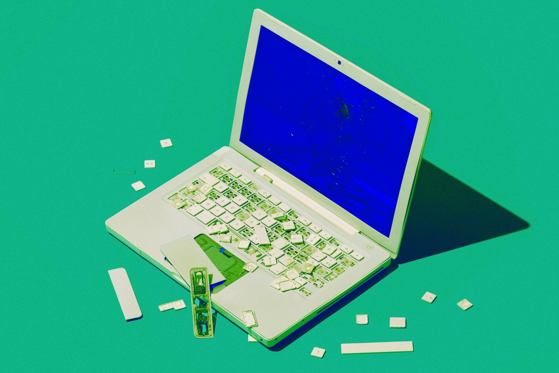 A color-treated photograph of a laptop that has been broken and smashed; it's screen has been turned bright blue, mimicking the old "blue screen of death."