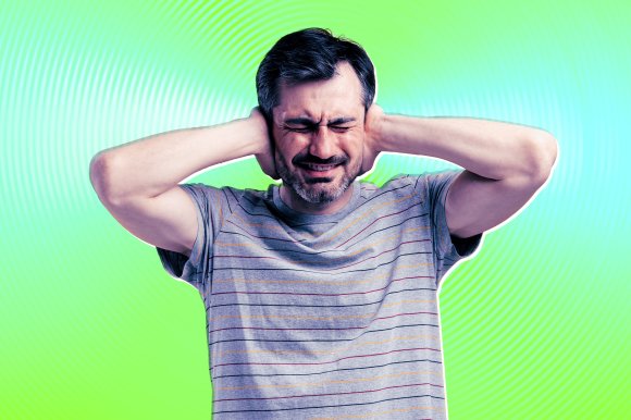 A photo illustration featuring a man with his hands over his ears trying to block out a loud noise.