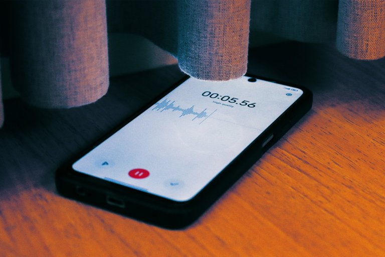 A color-treated photograph of a smartphone with a recording app turned on.