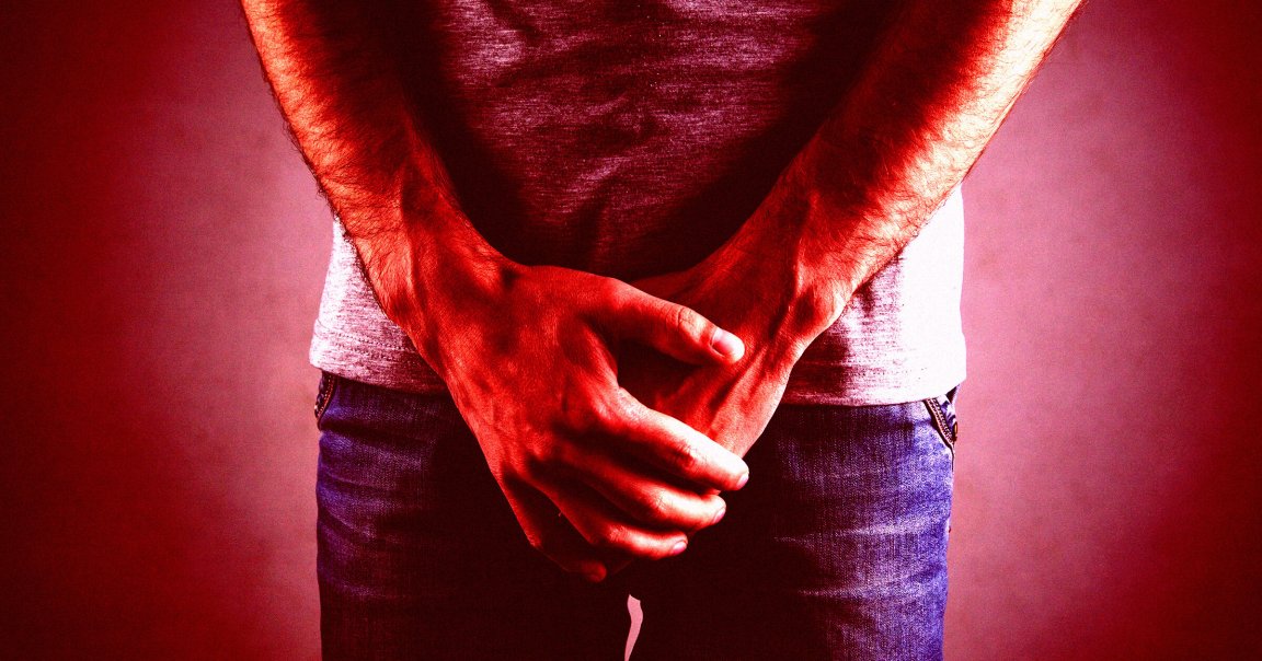 A color-treated photo of a man holding his hands over his crotch.