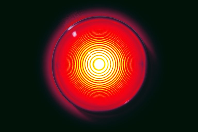 A photo illustration of a bright red warning light illuminated.