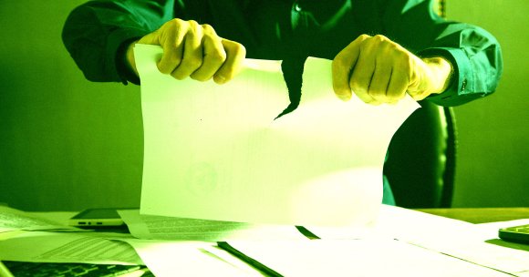A man ripping up a piece of paper.