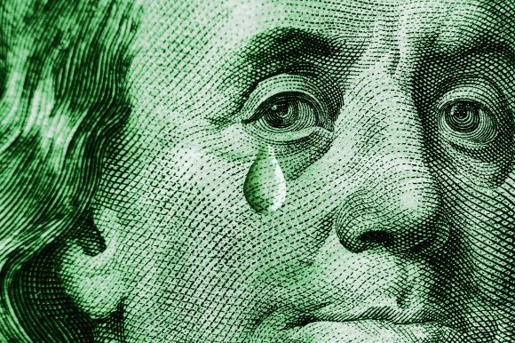 A color-treated close-up photograph of Benjamin Franklin's portrait on the U.S. $100 dollar bill. A single tear has been overlaid just underneath his eye.