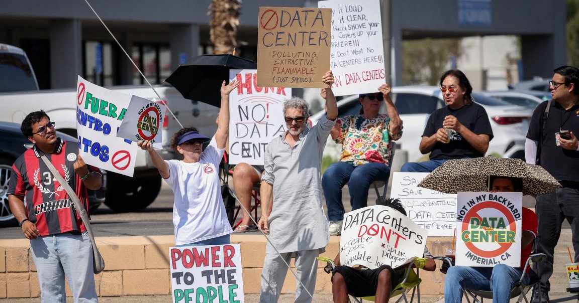 Demonstrators wave signs during a nationwide protest against AI data center expansion in Imperial, California.
