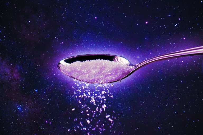 A photo illustration of space with a spoon imposed over it, full of a white granular substance.