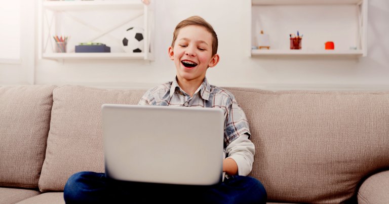 Boy has fun with computer at home.