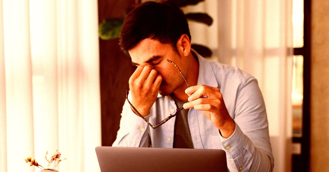A depressed man sitting at a desk.