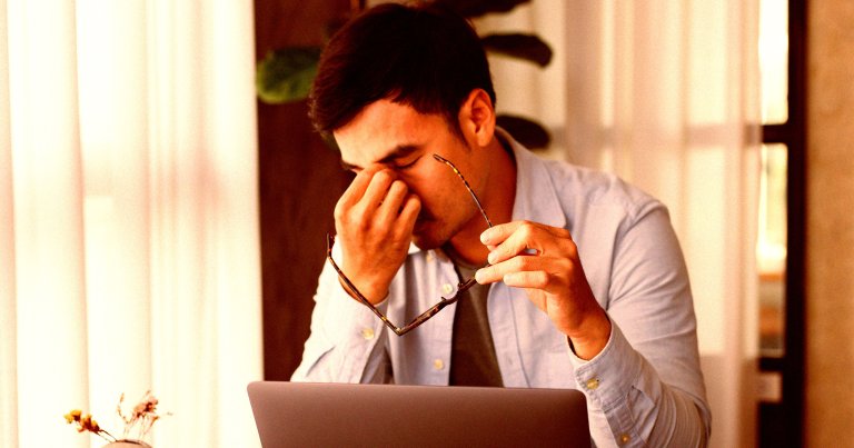 A depressed man sitting at a desk.