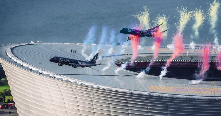 A photo showing two passenger planes flying closely over the DHL Stadium.