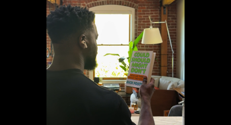 A screengrab from a leaked Apple video showing next-generation AirPods with cameras, scanning a book.