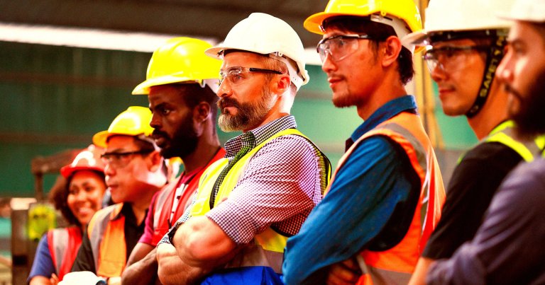 A row of construction workers crossing their arms.