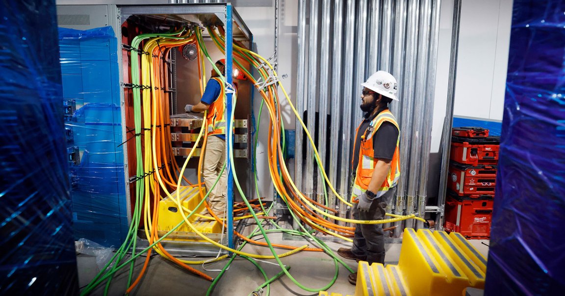 Construction workers wire electricity lines in Dallas TX4 data center's mechanical galley.