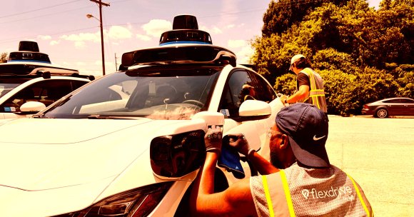 A man inspects a Waymo at the company's Nashville depot.