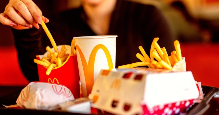 A photo of a woman eating a McDonald's meal.