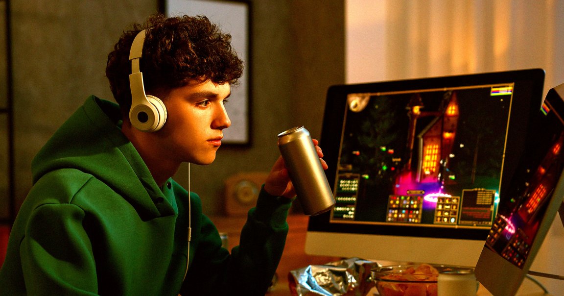 A photo of a young man sitting in front of a computer.