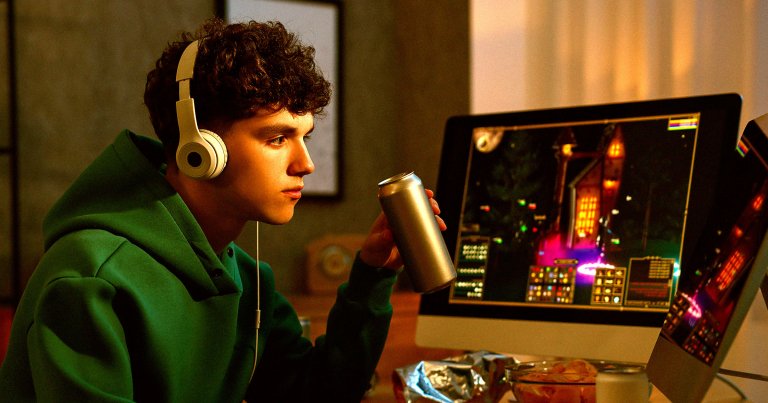 A photo of a young man sitting in front of a computer.