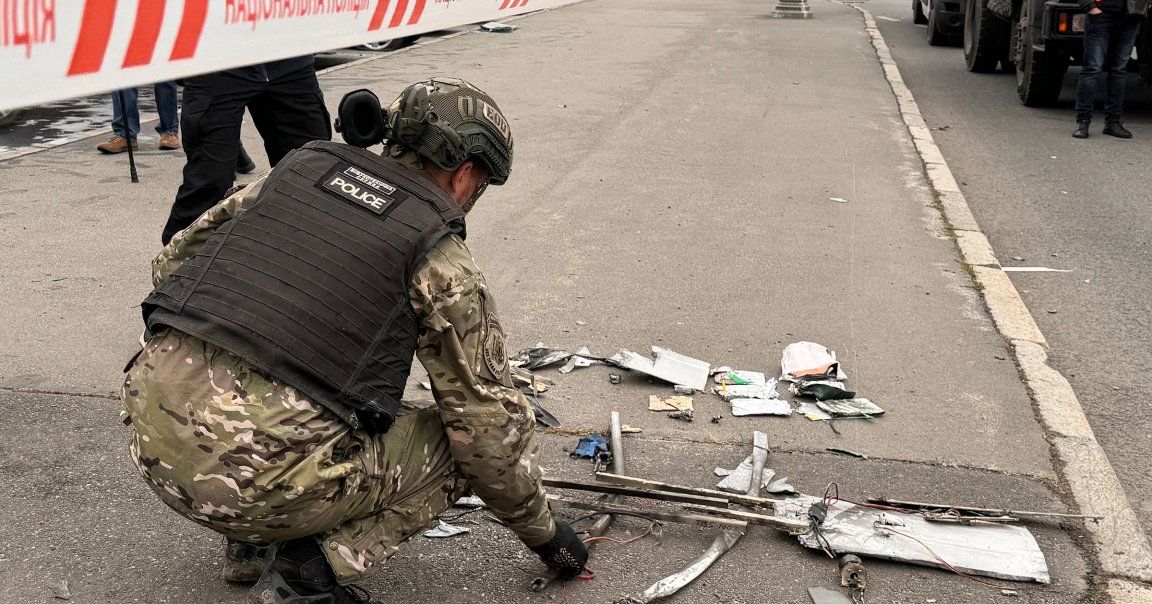 A police officer inspects collected fragments of a Russian kamikaze drone "Molniya-1" at the site of its impact.
