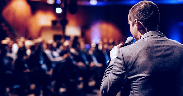 A man giving a presentation in front of a crowd.