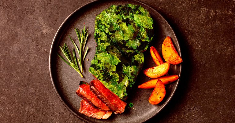 A photo illustration of a steak made out of lettuce.