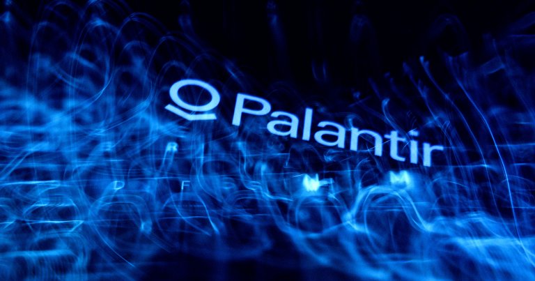 A laptop keyboard and Palantir logo displayed on a phone screen.