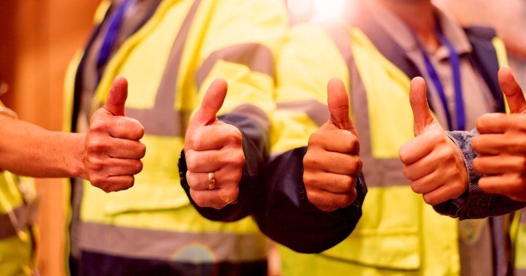 Construction workers giving the thumbs up.