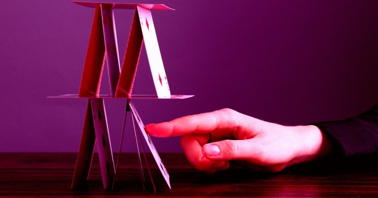 A house of cards being tipped over.