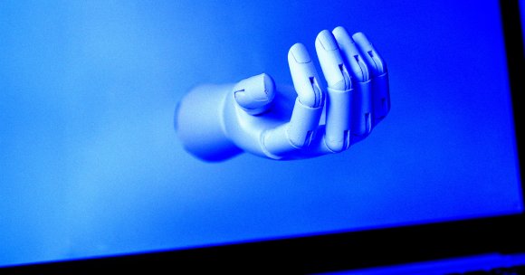 A robot hand on a laptop screen.
