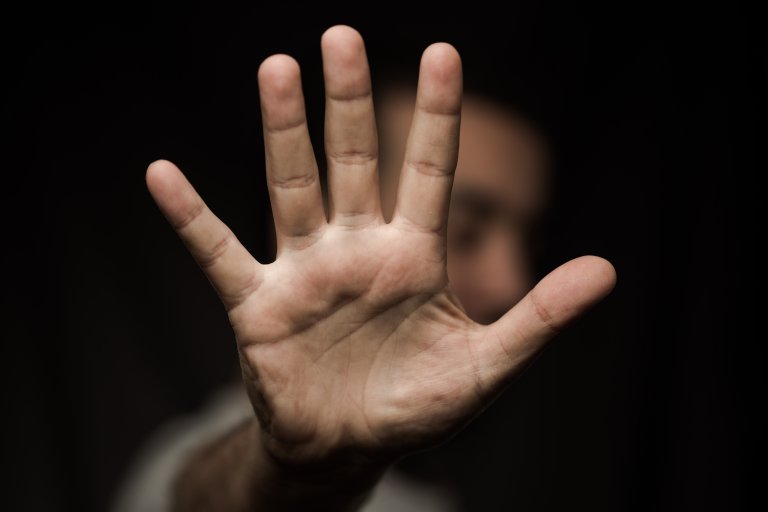 A stock photo shows a person holding up a hand in a "stop" motion.