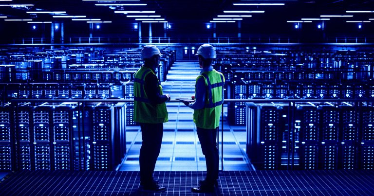 IT specialists talk inside a data center.