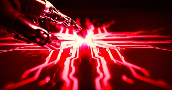 A robotic hand touches an electronic surface.