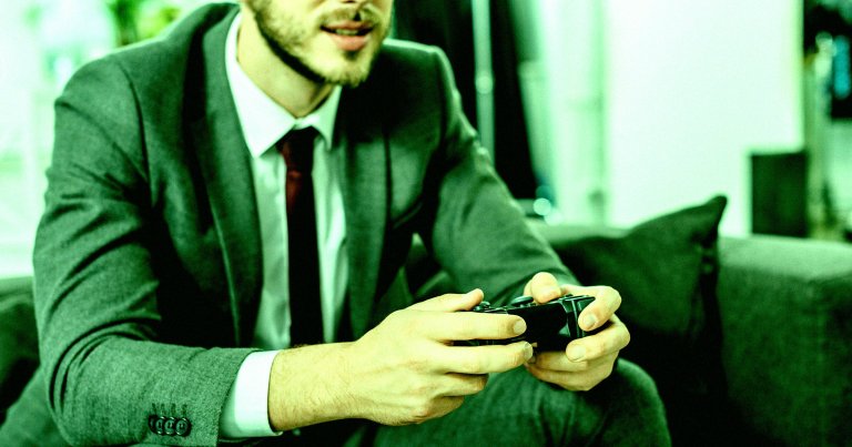 A man in a suit playing video games.