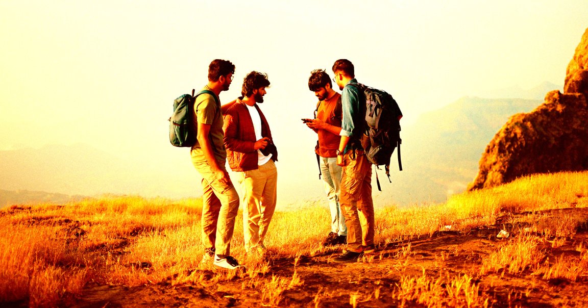 A group of hikers consulting a smartphone.