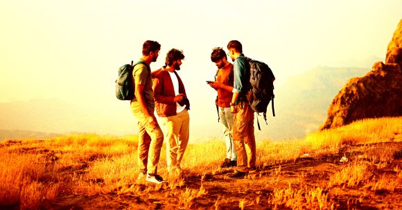 A group of hikers consulting a smartphone.