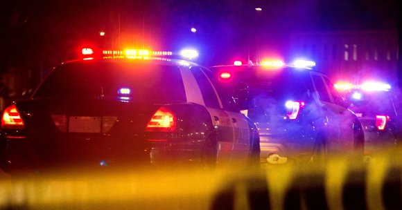 A photo of police cars with their lights turned on.