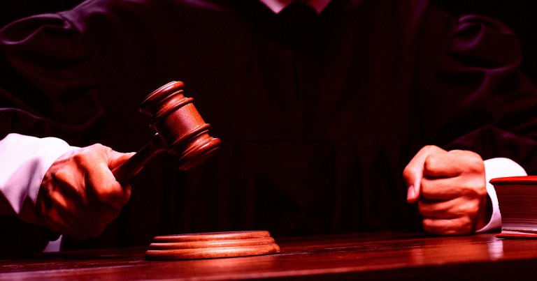 A color treated photo of a judge slamming a gavel.